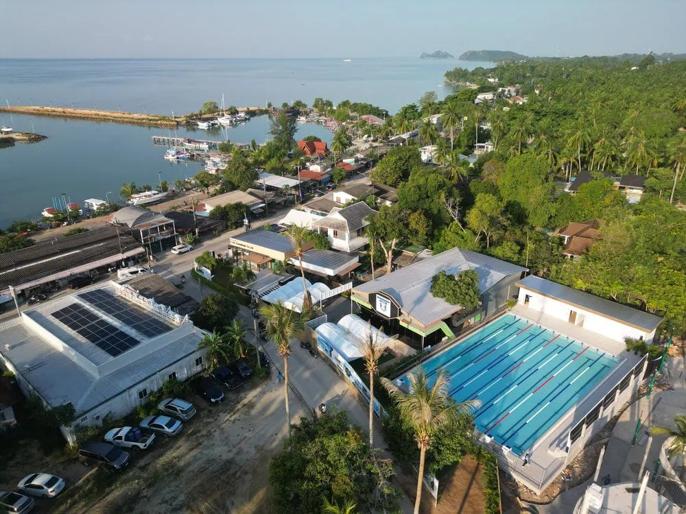 Aerial view of the ISPG campus, swimming pool and Koh Phangan coastline